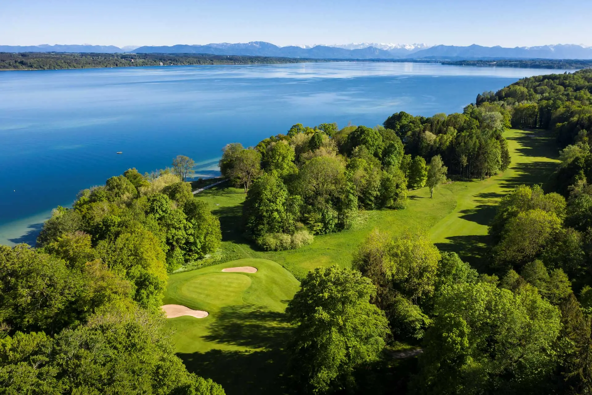 Golfplatz am See mit Bergpanorama